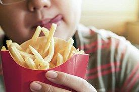 Criança a comer batatas fritas